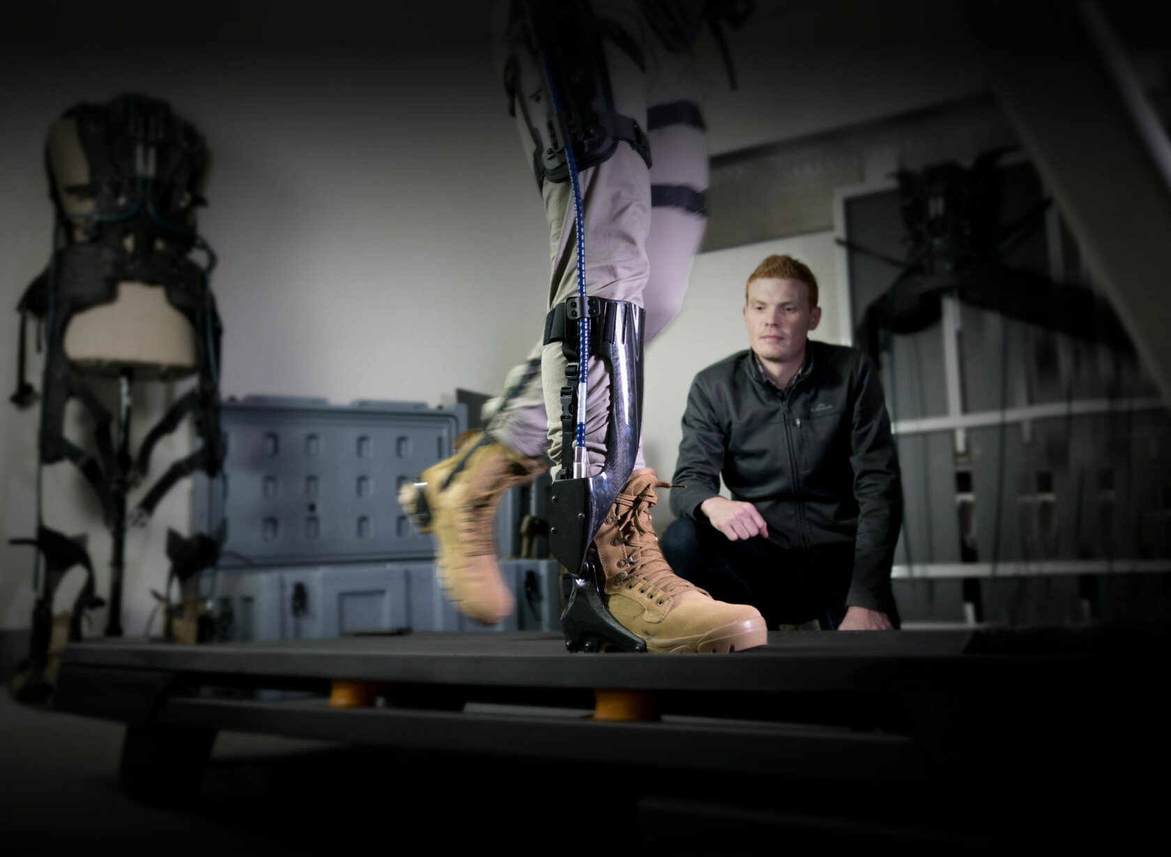 OX exoskeleton project leader observing user testing the equipment on a treadmill