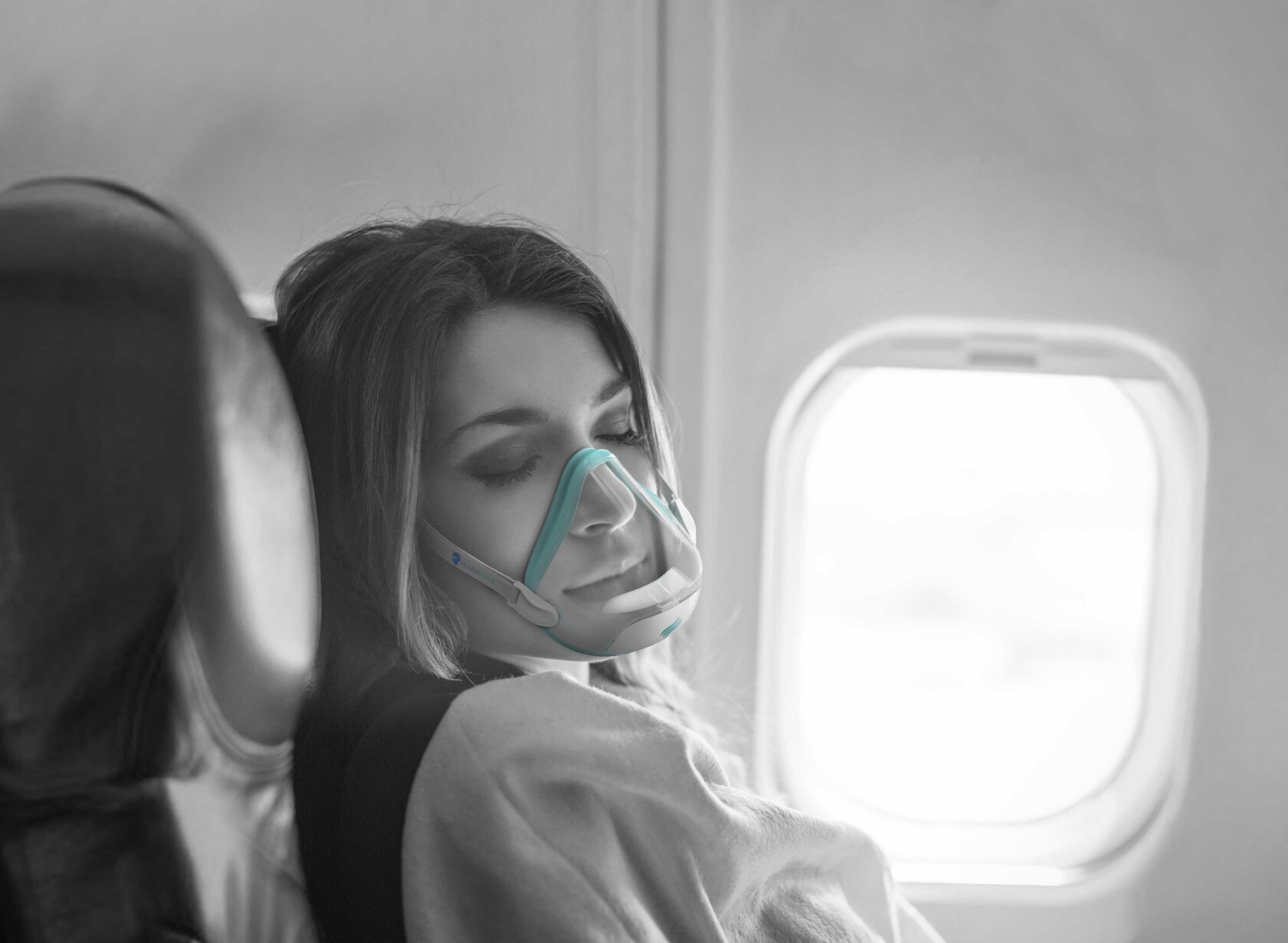 Woman sleeping on plane while wearing HumidiFlyer mask