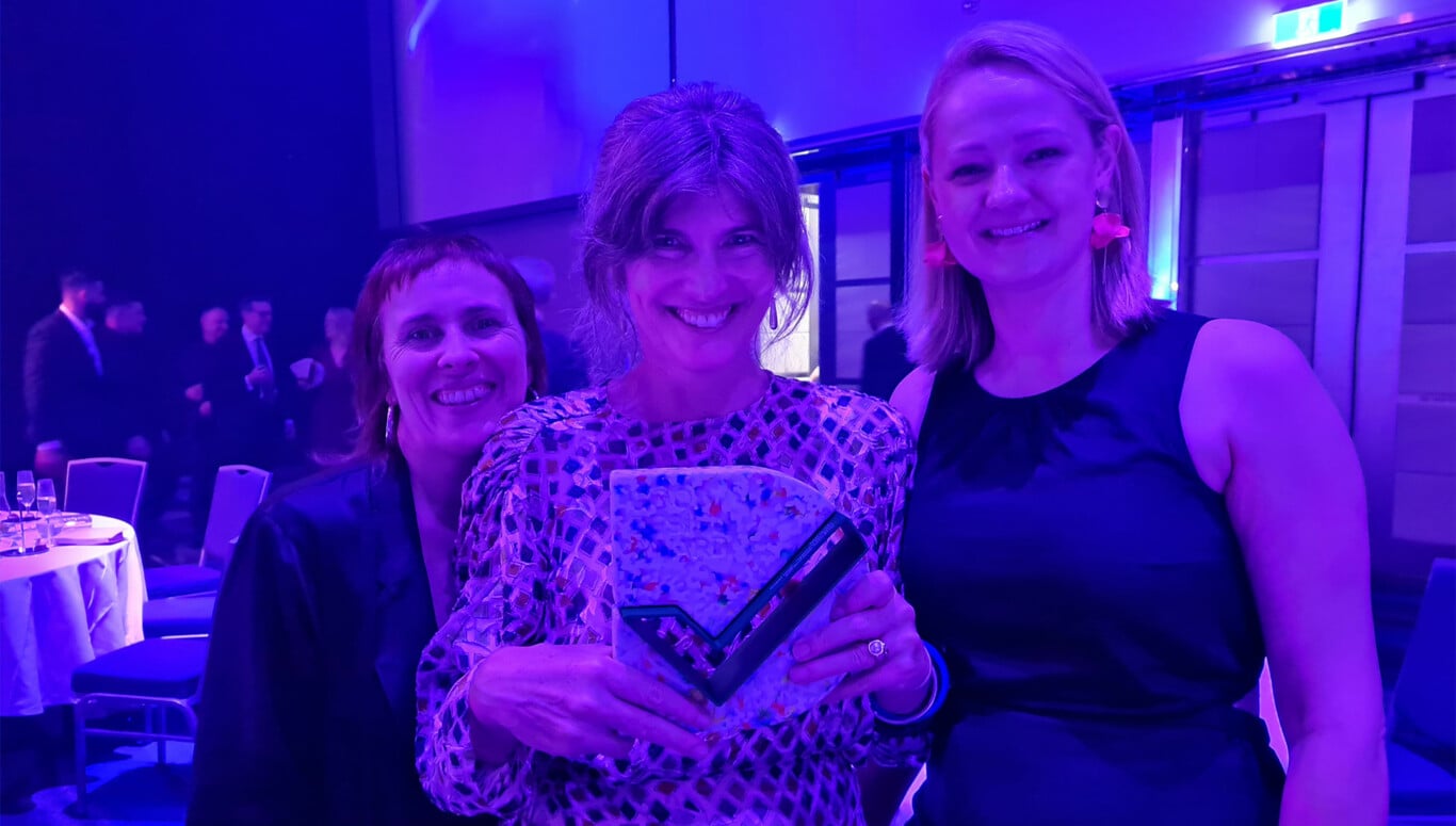 Lou Dyer, Abigail Forsyth, Kate Bednarz posing for a photo holding an award