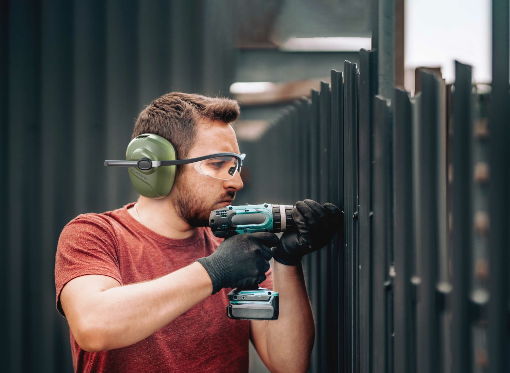 Man wearing EyeSonic and drilling into a fence.